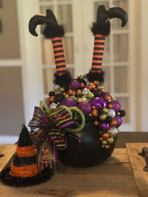 Two Halloween Decorations Sitting On Top Of A Wooden Table Next To A