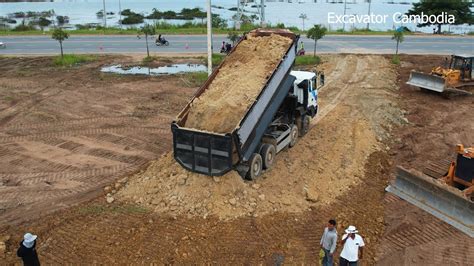 Building Road By Dump Truck Unloading Dirt And Bulldozer Pushing Dirt