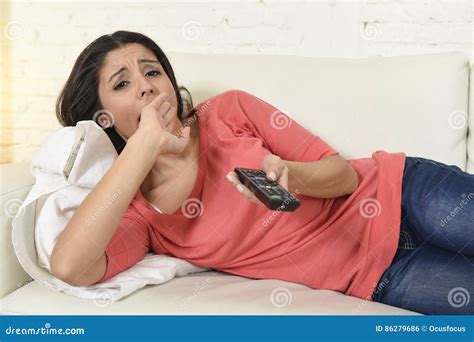 Young Beautiful Hispanic Woman At Home Watching Television Tired And