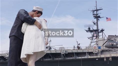 Kissing Sailor Statue At Tuna Harbor Park Uss Midway Aircraft Carrier In Background San Diego