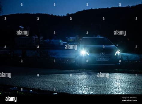 Dramatic night view of luxury Mercedes Benz car. Front view of premium Mercedes car with lights ...