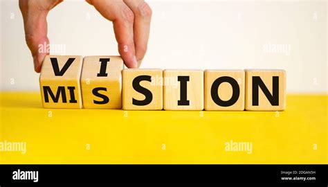 Mission vision symbol. Businessman hand turns wooden cubes and changes the word 'mission' to ...