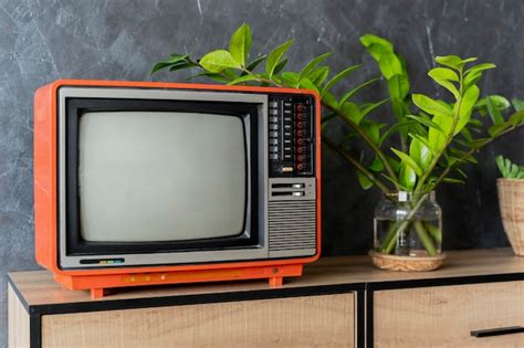 Premium Photo | Old orange tv on a wooden cabinet in the room of the ...