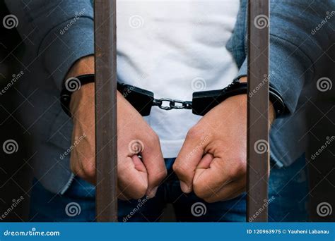 Handcuffed Hands Of A Businessman Behind The Bars Of A Prison C Stock