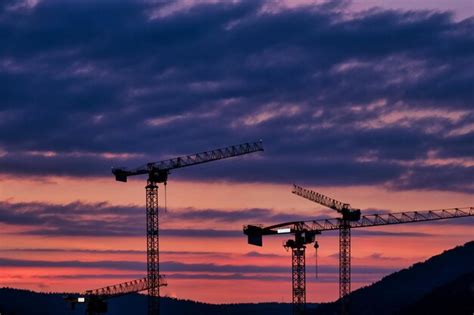 Premium Photo Low Angle View Of Silhouette Cranes Against Sky At Sunset