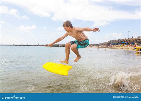 Teenboy Goza El Practicar Surf En Las Ondas Foto De Archivo Imagen De