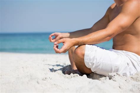 Low Section Of Shirtless Man Meditating At Beach Stock Photo Image Of