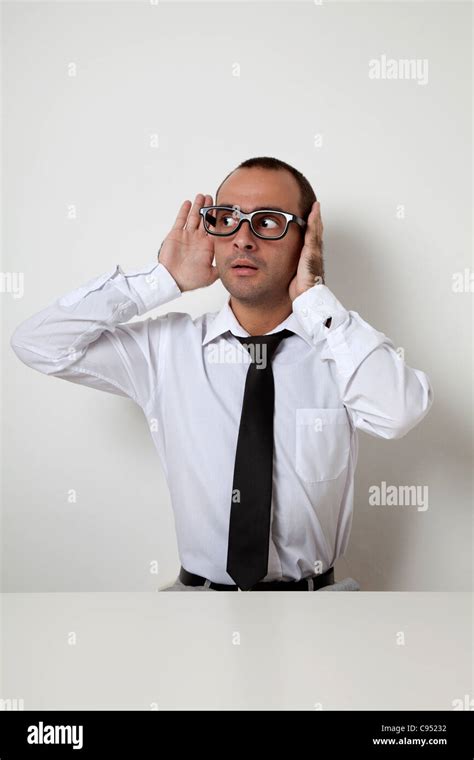 Man Half Covering His Ears In Workplace Stock Photo Alamy