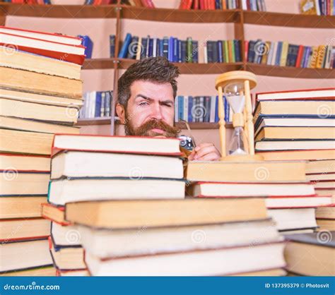 Man Scientist Peeking Out Of Piles Of Books With Alarm Clock Teacher