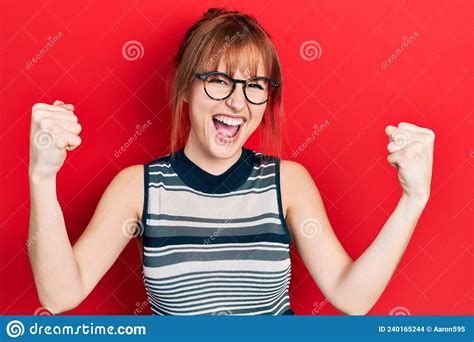 Redhead Young Woman Wearing Casual Clothes And Glasses Screaming Proud Celebrating Victory And