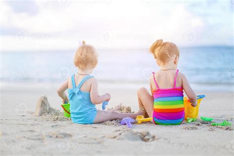 Two kids making sand castle and having fun at tropical beach 18037424 Stock Photo at Vecteezy