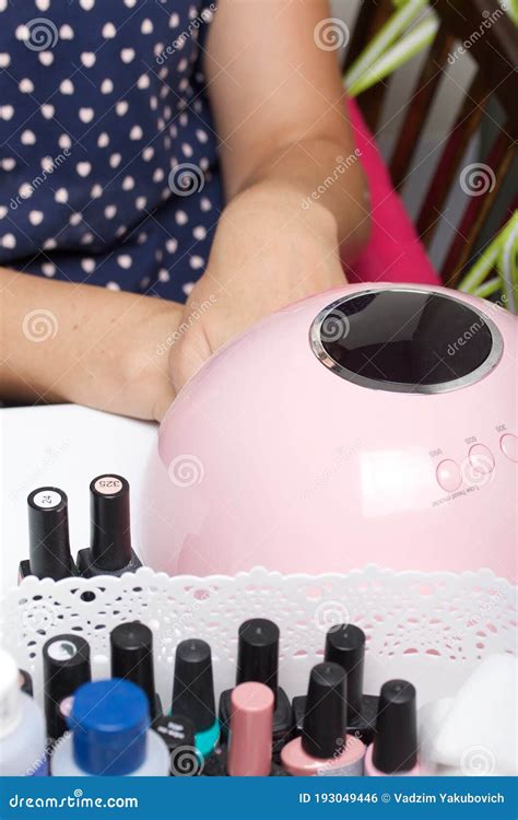 A Woman Gives Herself A Manicure Dries The Varnish In A Uv Lamp Stock