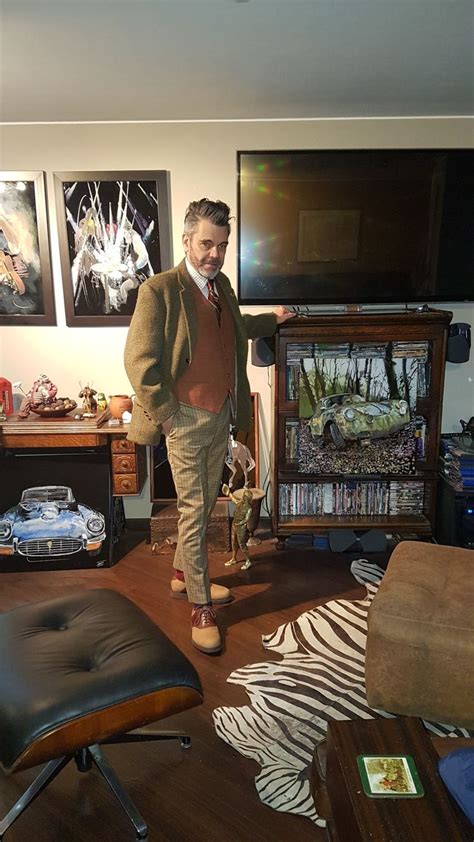 A Man Standing In The Middle Of A Living Room Next To A Zebra Print Rug