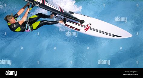 Aerial View Of Single Female Windsurfer Sailing On Clear Blue Water Of