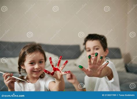 Happy Children Showing Their Hands Smeared With Colored Paints To The