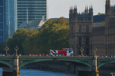 Gente explorando el puente de westminster sobre el río támesis con el