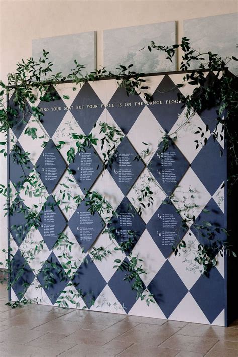 The Wall Is Decorated With Blue And White Checkered Tiles Greenery On