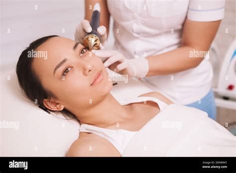 Young Beautiful Asian Woman Receiving Anti Aging Facial Treatment By