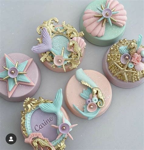 There Are Four Decorated Cookies In The Shape Of Mermaids And Seashells