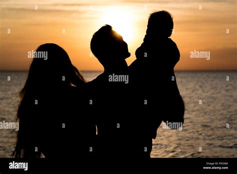 Silhouette of happy family sunset beach Stock Photo - Alamy