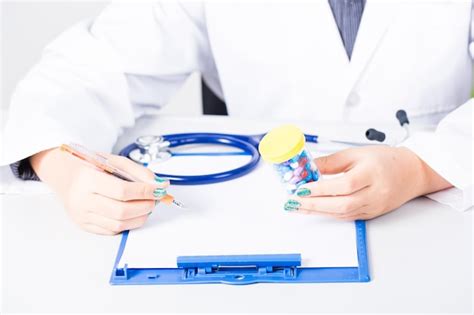 Premium Photo Midsection Of Female Doctor Writing On Paper In Office