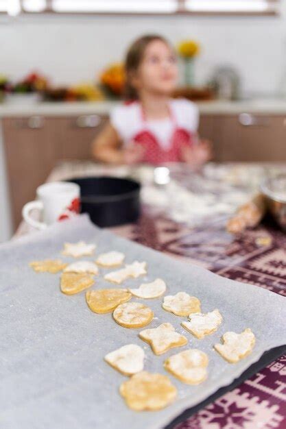 Niña haciendo galletas de jengibre en casa Foto Premium