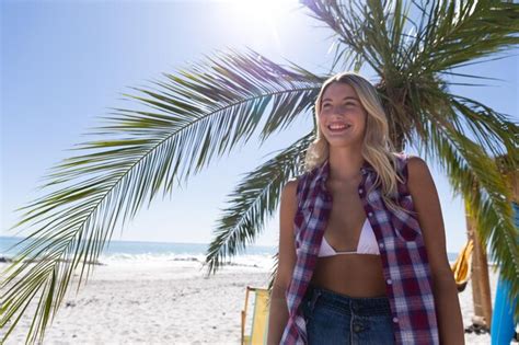 Mujer caucásica disfrutando del tiempo en la playa en un día soleado