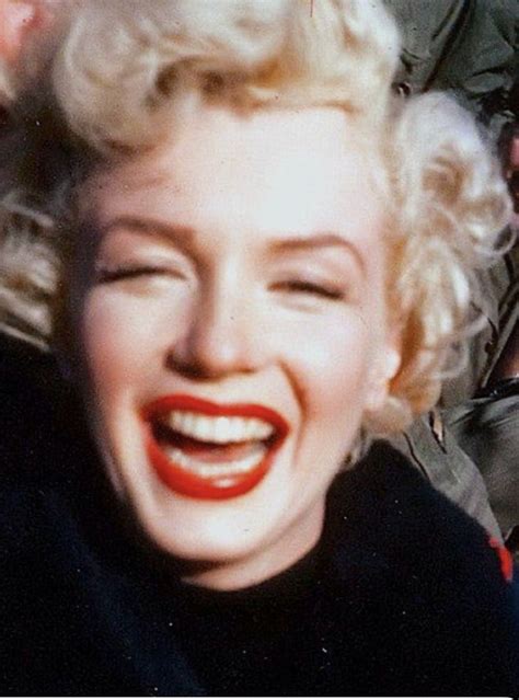 marilyn monroe laughing while standing next to other people