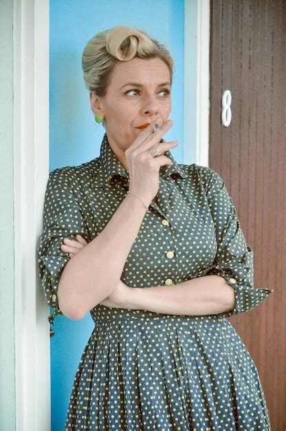 Premium Photo Mature Woman Smoking Cigarette While Standing Against Door