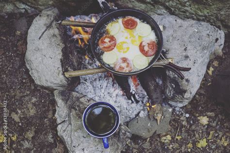 Cooking breakfast on a campfire at a summer camp. Stock Photo | Adobe Stock