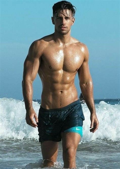 A Man Standing In The Ocean With His Shirt Off