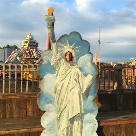 Mujer detrás de la réplica de la Estatua de la Libertad en un parque de