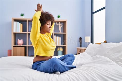 African American Woman Doing Yoga Exercise Sitting On Bed At Bedroom