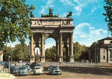 An Old Postcard Shows Cars Parked In Front Of The Arch With Statues On Top