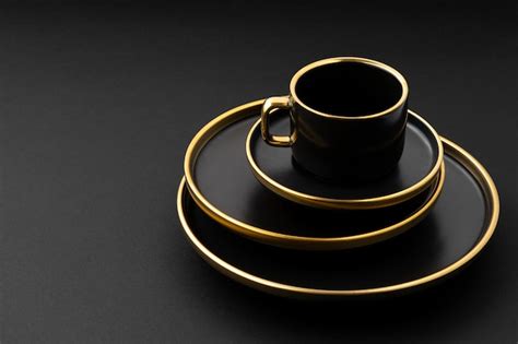 Premium Photo A Set Of Black And Golden Ceramic Plates And Cup On A