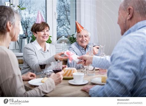 Zwei Ltere Paare Feiern Geburtstag Und Sto En Mit Rotwein An Ein