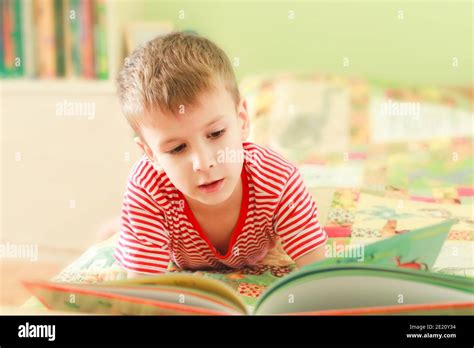 Un Petit Garçon Mignon Lisant Un Livre à Lalphabet Tout En étant