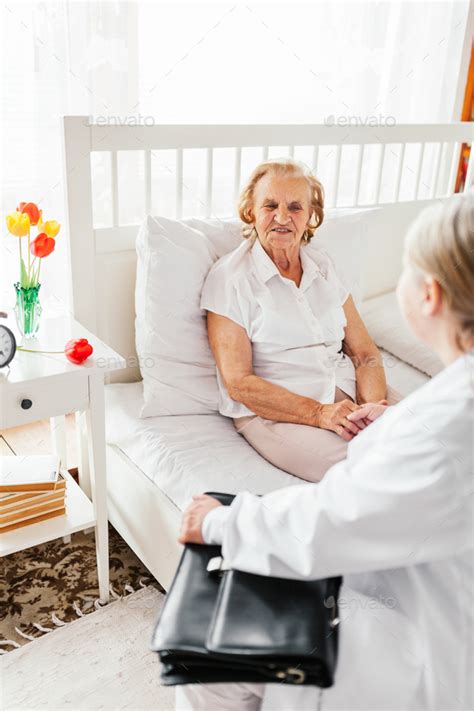 Providing Care For Elderly Doctor Visiting Elderly Patient At Home