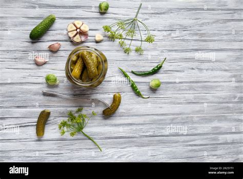 Pickled Cucumbers In An Open Jar Gherkin On A Fork And Garlic On A