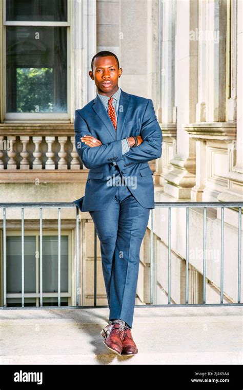 Man Urban Fashion. Dressing in blue suit, tie, leather shoes, a young black businessman sitting ...