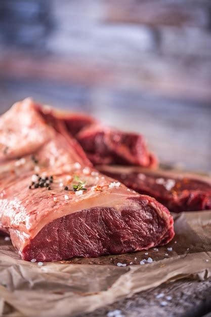 Premium Photo Raw Rib Eye Beef Steak With Salt Spices And Herbs