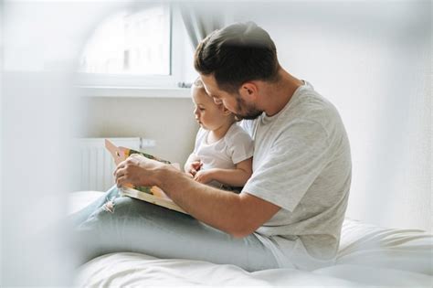 Feliz Pai Jovem E Filha Pequena Se Divertindo Lendo Um Livro No Quarto