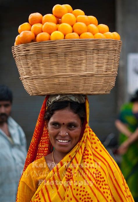 Indian Woman Carrying A Basket Of Oranges On Her Head To Markets We Are