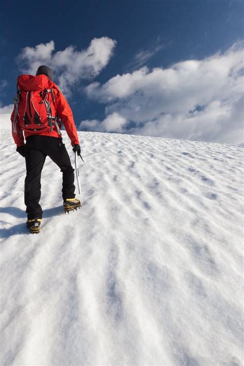 Alpinista Che Cammina In Salita Lungo Un Pendio Nevoso Fotografia Stock