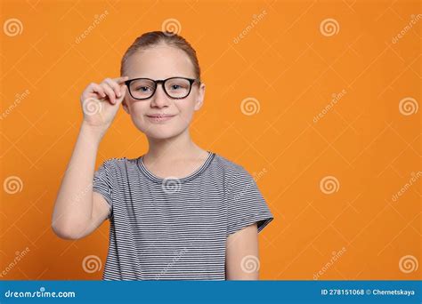 Portrait Of Cute Girl In Glasses On Orange Background Space For Text