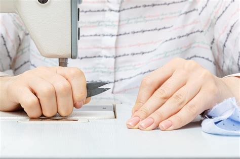 Manos Femeninas De Un Maestro Sastre Corta Un Hilo Con Unas Tijeras