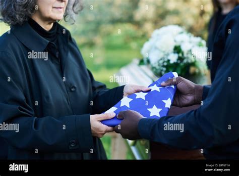 Mature Grieving Widow In Black Attire Taking Folded Stars And Stripes