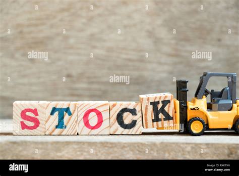 Toy Forklift Hold Letter Block K To Complete Word Stock On Wood