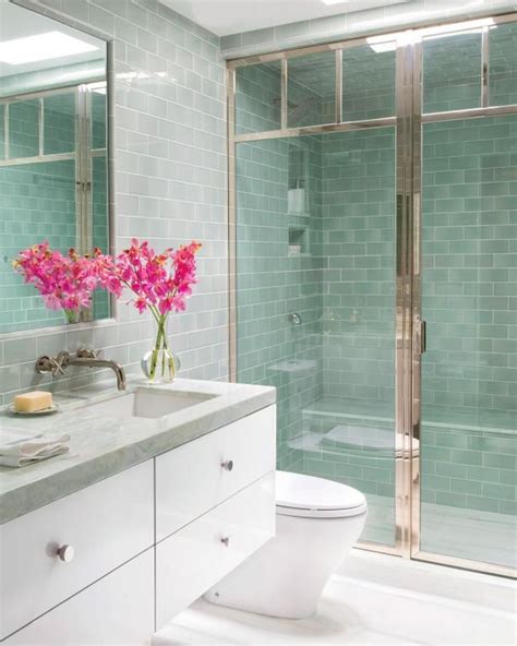 HGTV loves this bright, modern bathroom that features sea green glass subway wall tiles, white ...