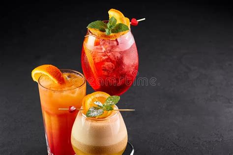 Three Alcoholic Cocktails Red Orange And Yellow Colors On Black Backdrop Variety Of Alcoholic